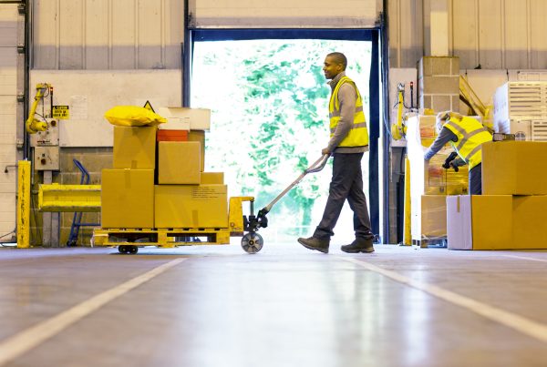 A Worker Struggling to Move a Cumbersome Pallet Jack.