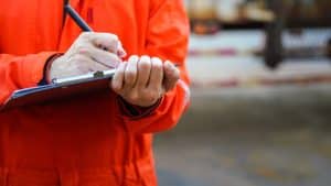 Warehouse Safety Checklist Being Filled Out By Worker.